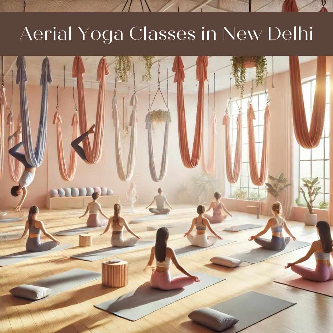 A peaceful yoga studio at The Pink Lotus Academia in New Delhi NCR with soft natural lighting. People are practicing aerial yoga using suspended silk hammocks, performing various yoga poses mid-air. The space is serene, featuring pastel tones and a minimalistic design, creating a calm and inviting atmosphere.