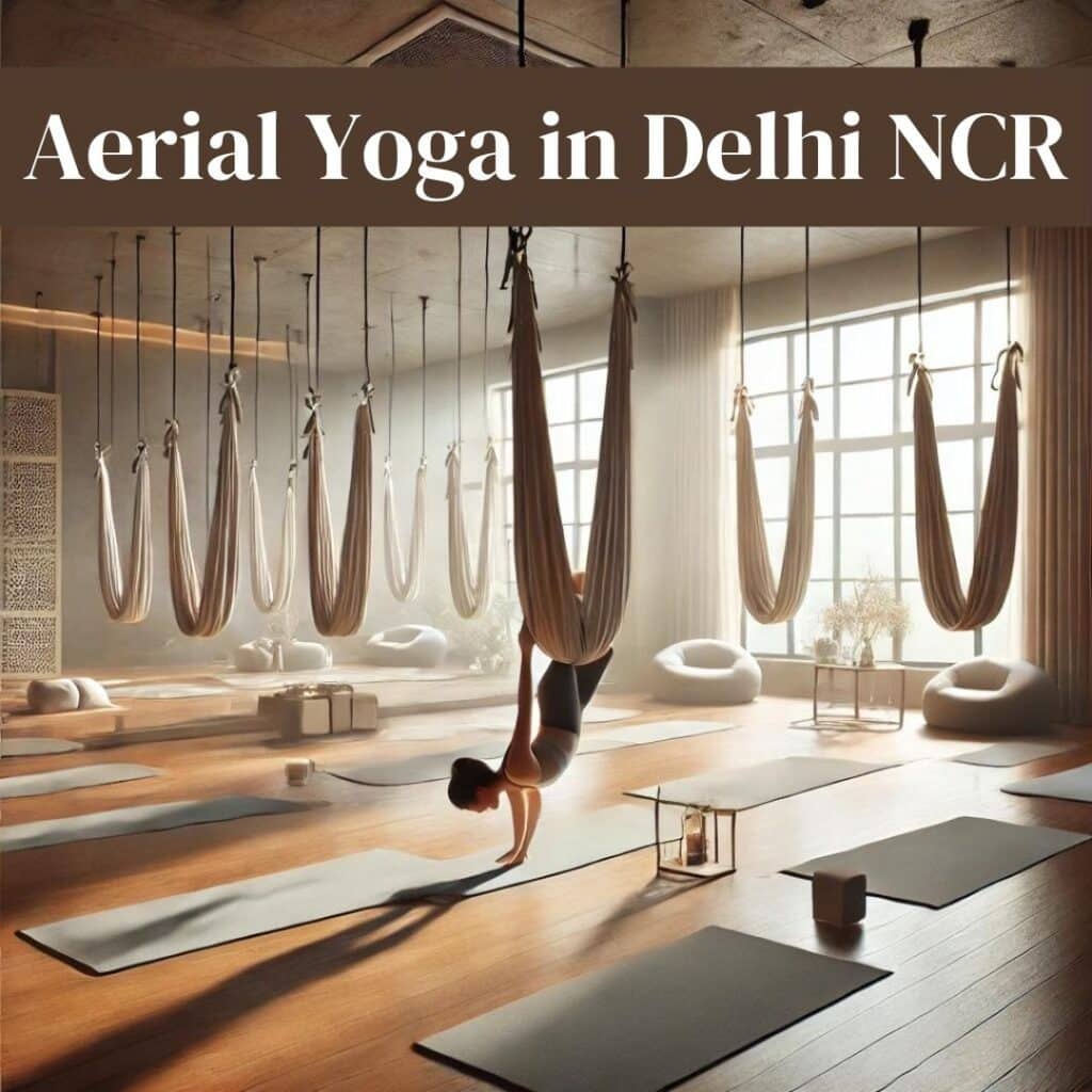 A serene yoga studio with suspended hammocks, wooden flooring, and natural lighting. A person is practicing an inverted aerial yoga pose in a calm and tranquil environment.